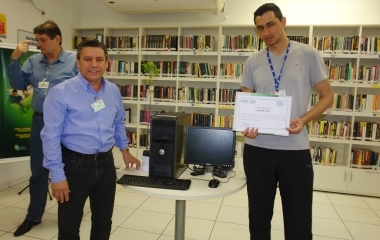 Jean Carlos dos Santos recebendo o computador do Chefe João Carlos da Silva (Foto: Divulgação/WEG)