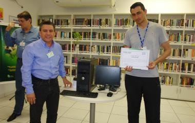 Jean Carlos dos Santos recebendo o computador do Chefe João Carlos da Silva (Foto: Divulgação/WEG)