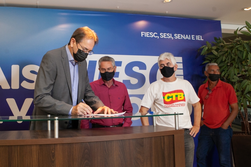 Aguiar assina acordo ao lado de Castanheira (camisa vinho) e outros representantes dos trabalhadores (foto: Filipe Scotti)
