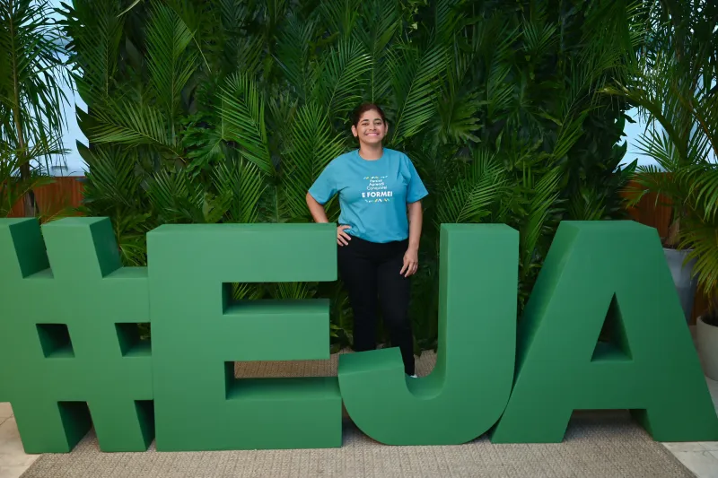 Estudante em logomarca da EJA do SESI/SC durante formatura em 2024 (Fabrício de Almeida)