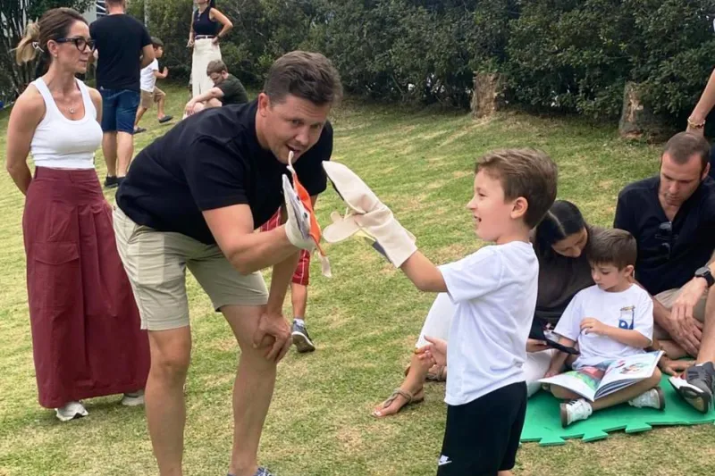 Pai brinca de fantoche com filho no pátio da Escola SESI