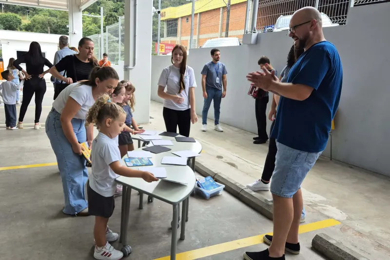 Menina brinca com livro no pátio da escola